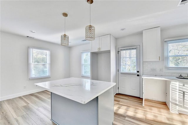 2502 Tupelo St SE, Atlanta, GA 30317 - kitchen featuring plenty of natural light, light wood finished floors, light stone counters, a kitchen island, and recessed lighting