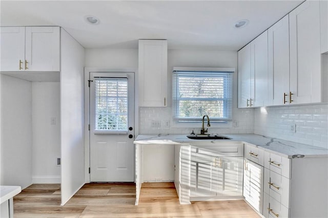 2502 Tupelo St SE, Atlanta, GA 30317 - kitchen with light stone countertops, light wood-type flooring, white cabinetry, backsplash, and recessed lighting