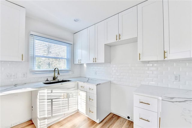 2502 Tupelo St SE, Atlanta, GA 30317 - kitchen featuring a sink, light stone counters, white cabinetry, and light wood-style flooring