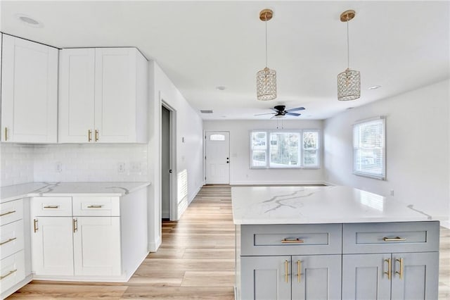 2502 Tupelo St SE, Atlanta, GA 30317 - kitchen with a ceiling fan, light stone countertops, gray cabinetry, and decorative backsplash
