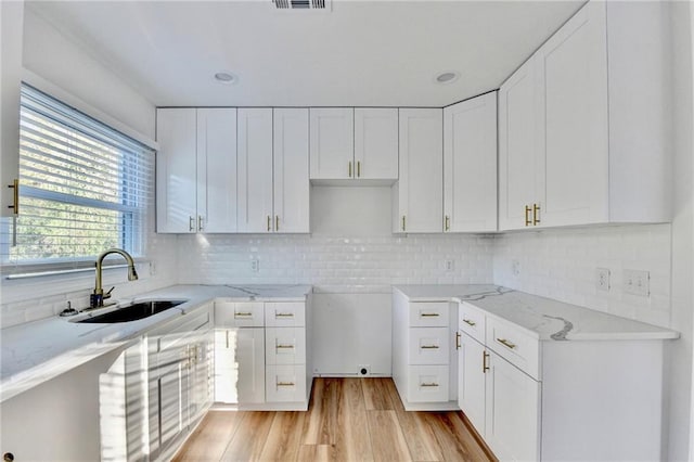 2502 Tupelo St SE, Atlanta, GA 30317 - kitchen featuring a sink, light stone countertops, light wood-style flooring, and white cabinets