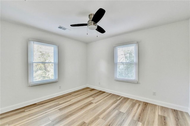 2502 Tupelo St SE, Atlanta, GA 30317 - empty room with healthy amount of natural light, wood finished floors, baseboards, and a ceiling fan