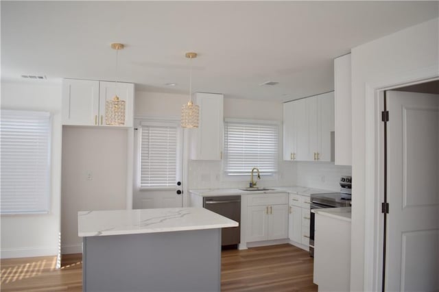 2502 Tupelo St SE, Atlanta, GA 30317 - kitchen with stainless steel appliances, a sink, wood finished floors, and backsplash