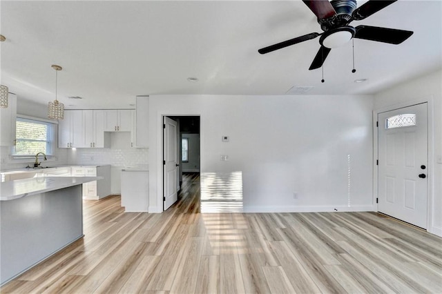 2502 Tupelo St SE, Atlanta, GA 30317 - kitchen with a sink, light wood-style flooring, white cabinetry, pendant lighting, and open floor plan