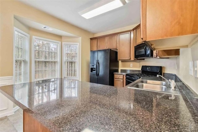 kitchen featuring black appliances, light tile patterned flooring, kitchen peninsula, and sink