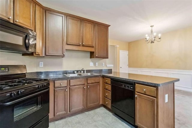 kitchen featuring black appliances, sink, hanging light fixtures, a notable chandelier, and kitchen peninsula