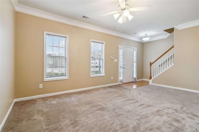 carpeted foyer with crown molding and ceiling fan