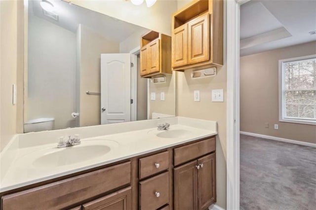 bathroom with vanity, a tray ceiling, and toilet