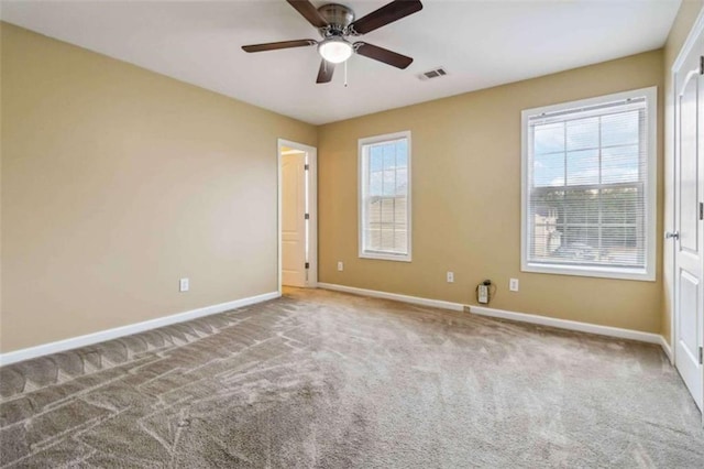 carpeted empty room featuring plenty of natural light and ceiling fan