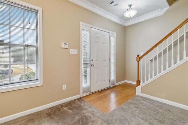 foyer entrance featuring hardwood / wood-style floors, plenty of natural light, and crown molding