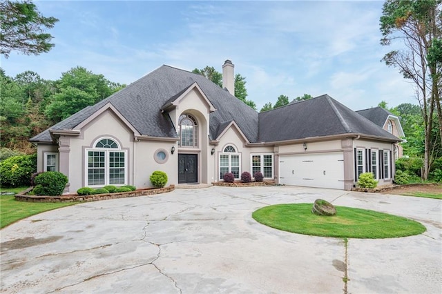 6065 Standard View Dr, Duluth, GA 30097 - french country style house with curved driveway, stucco siding, a chimney, and an attached garage
