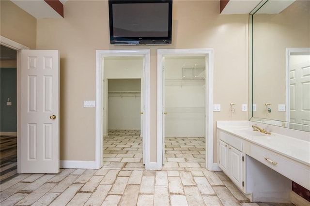 6065 Standard View Dr, Duluth, GA 30097 - bathroom featuring vanity, brick flooring, baseboards, and a walk in closet
