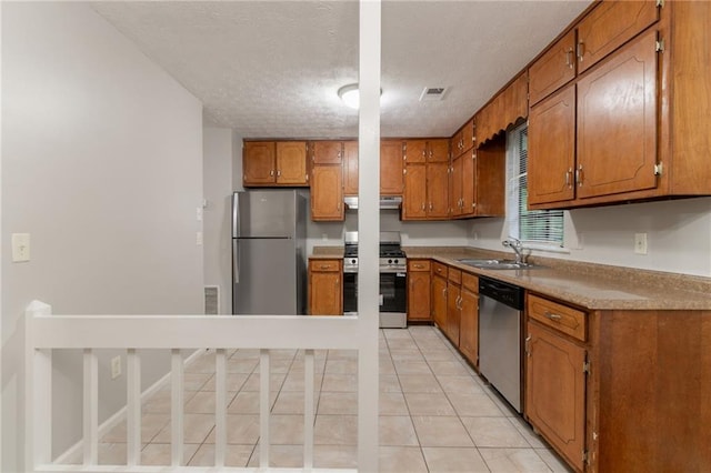 5218 Tina Ct, Stone Mountain, GA 30083 - kitchen with appliances with stainless steel finishes, a sink, brown cabinets, range hood, and a textured ceiling