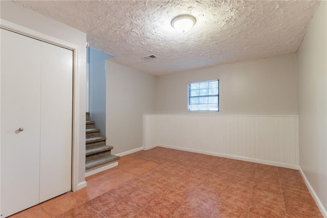 5218 Tina Ct, Stone Mountain, GA 30083 - below grade area with a textured ceiling, stairs, and a wainscoted wall