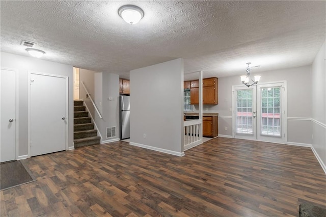 5218 Tina Ct, Stone Mountain, GA 30083 - unfurnished living room with dark wood finished floors, a textured ceiling, stairway, baseboards, and a chandelier