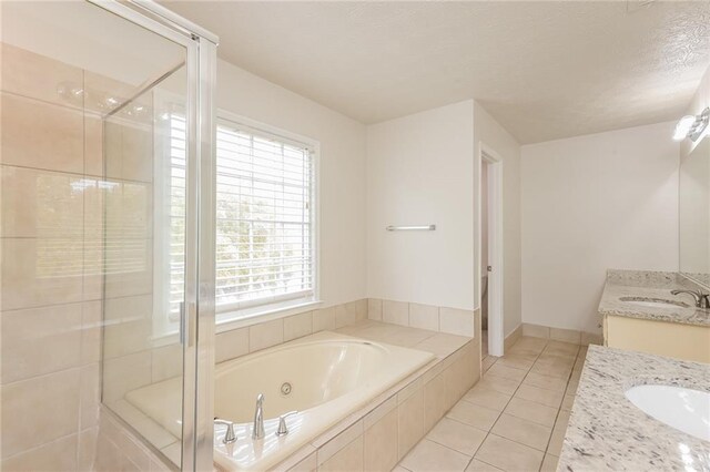 bathroom with vanity, independent shower and bath, a healthy amount of sunlight, and tile patterned floors