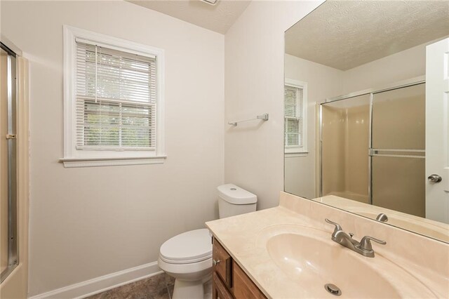 bathroom featuring toilet, vanity, a textured ceiling, and tile patterned flooring