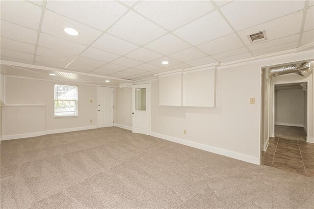 carpeted empty room featuring a drop ceiling