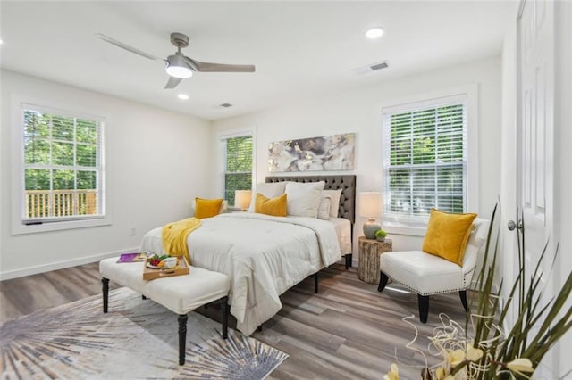 bedroom featuring hardwood / wood-style flooring, multiple windows, and ceiling fan