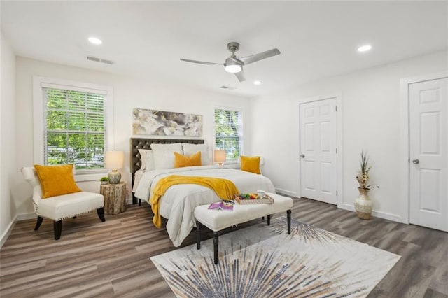 bedroom featuring wood-type flooring, multiple windows, and ceiling fan