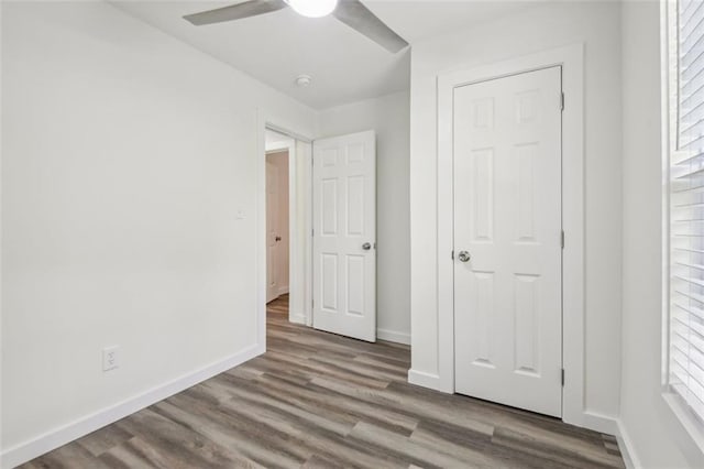 unfurnished bedroom featuring a closet, hardwood / wood-style flooring, and ceiling fan