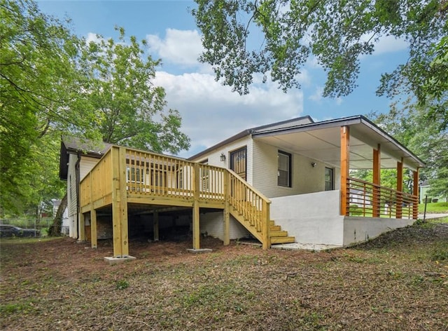 rear view of house featuring a wooden deck