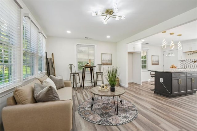 living room with a chandelier and light wood-type flooring