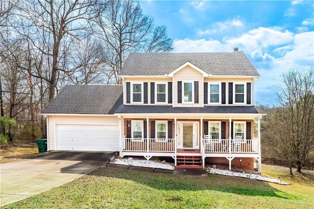 colonial home featuring a porch, a garage, and a front yard