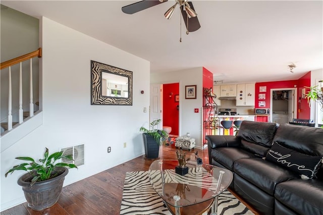 living room featuring ceiling fan and dark hardwood / wood-style flooring