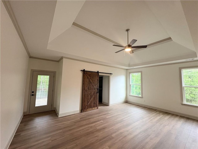 4786 Conns Creek Rd, Ball Ground, GA 30107 - empty room featuring a barn door, a raised ceiling, wood finished floors, and crown molding