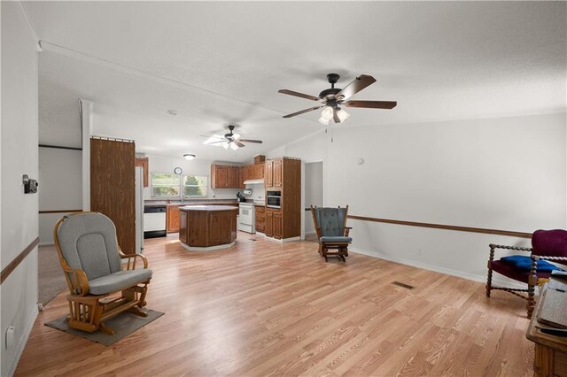 living area featuring light wood-type flooring, lofted ceiling, ceiling fan, and baseboards