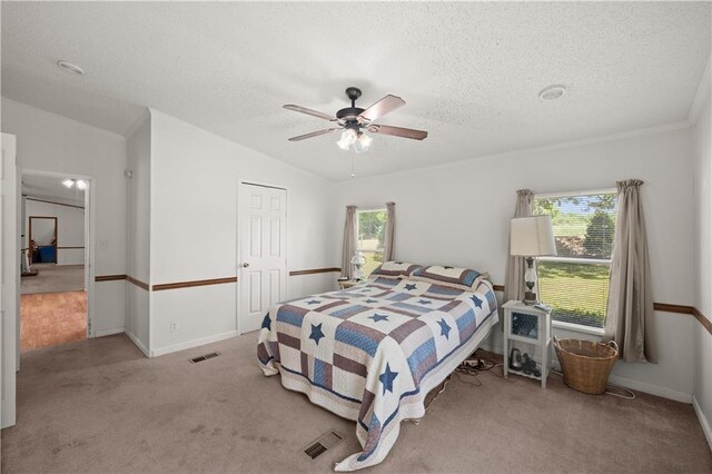 carpeted bedroom with multiple windows, a textured ceiling, ceiling fan, and baseboards