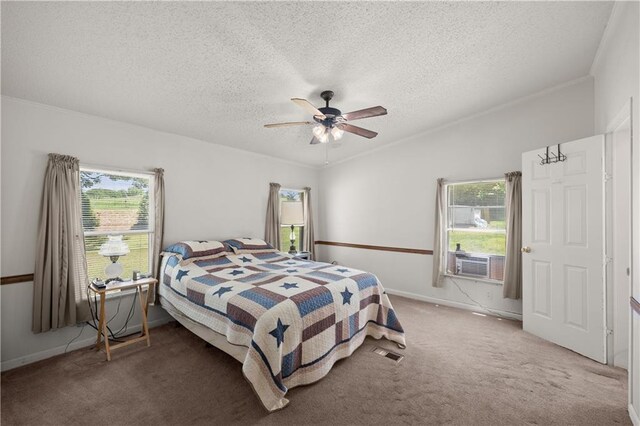 carpeted bedroom with a textured ceiling, ceiling fan, baseboards, cooling unit, and crown molding