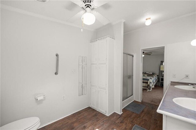 full bathroom with a ceiling fan, wood finished floors, crown molding, a shower stall, and toilet