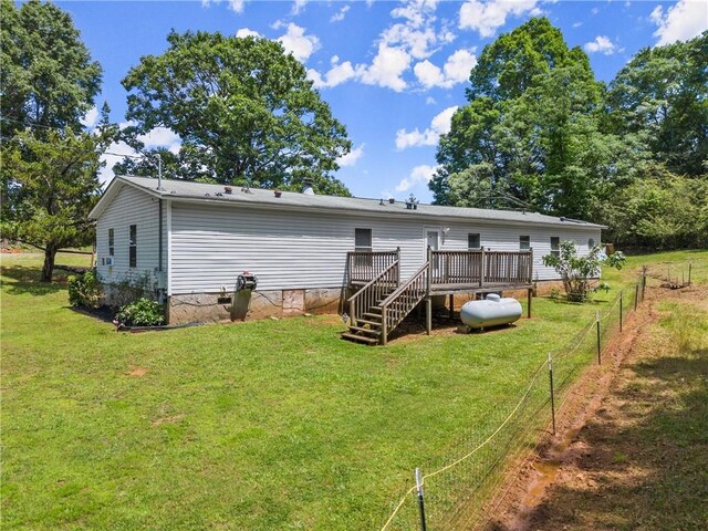 rear view of property featuring a deck and crawl space