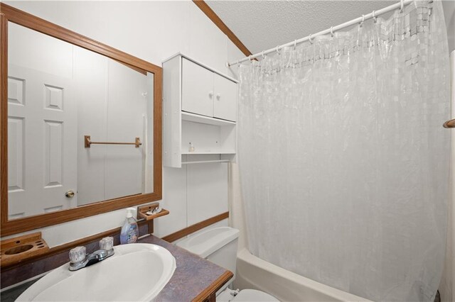 full bathroom with toilet, a textured ceiling, vanity, and shower / tub combo
