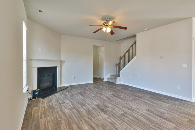 unfurnished living room featuring wood-type flooring and ceiling fan