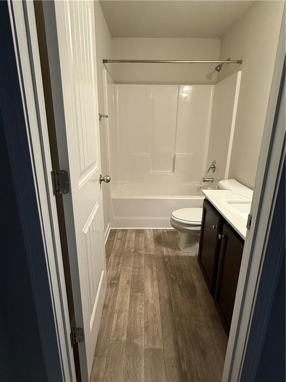 full bathroom featuring shower / bath combination, vanity, hardwood / wood-style floors, and toilet