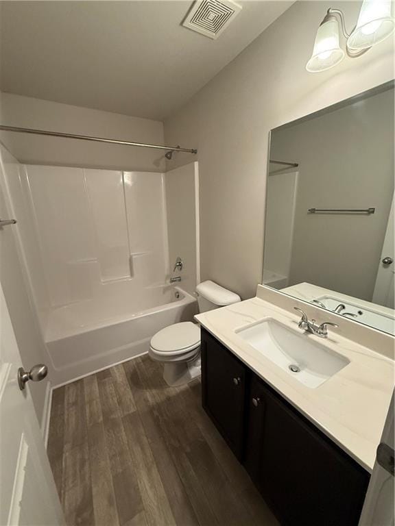 full bathroom with hardwood / wood-style flooring,  shower combination, toilet, and vanity