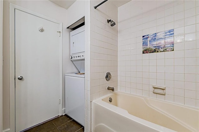 bathroom featuring tile patterned flooring, stacked washing maching and dryer, and tiled shower / bath