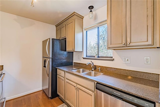 kitchen featuring light brown cabinetry, sink, light hardwood / wood-style flooring, and appliances with stainless steel finishes