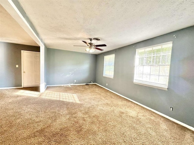 spare room with carpet flooring, a textured ceiling, and ceiling fan