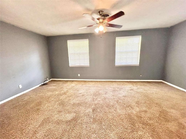 unfurnished room with a wealth of natural light, ceiling fan, and carpet flooring