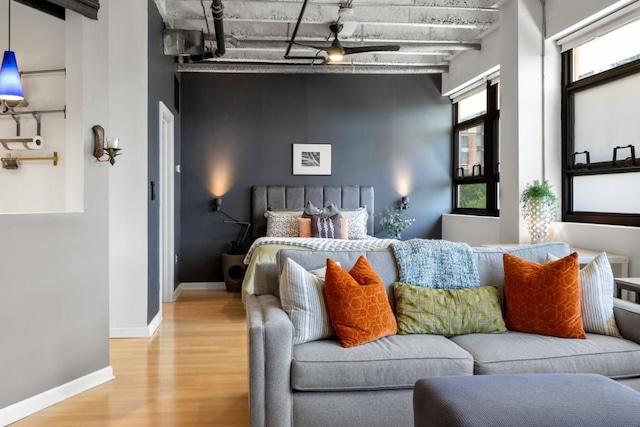 bedroom with a towering ceiling, rail lighting, and light hardwood / wood-style flooring