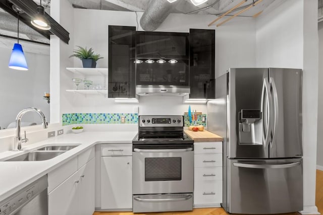 kitchen with stainless steel appliances, sink, pendant lighting, and white cabinets