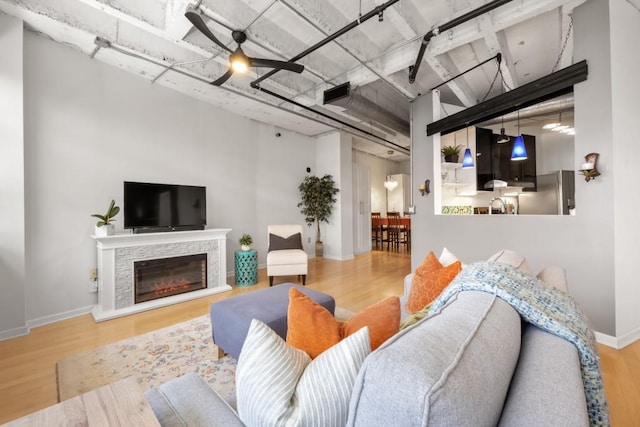 living room with wood-type flooring and a stone fireplace