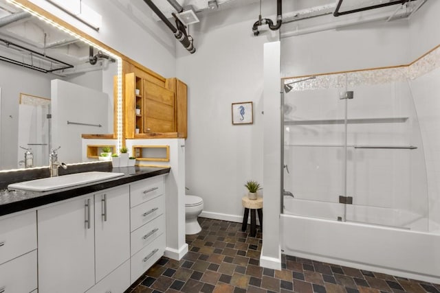 full bathroom featuring vanity, shower / bath combination with glass door, and toilet