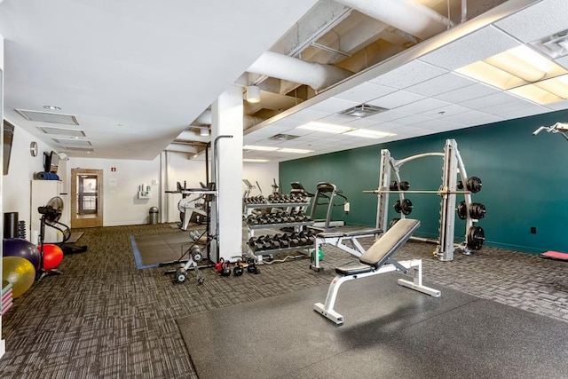 gym featuring carpet floors and a drop ceiling