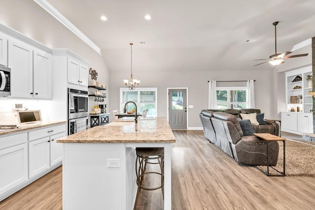 2980 Beards Rd, Buford, GA 30518 - kitchen featuring a sink, open floor plan, light wood-type flooring, white cabinets, and light stone counters