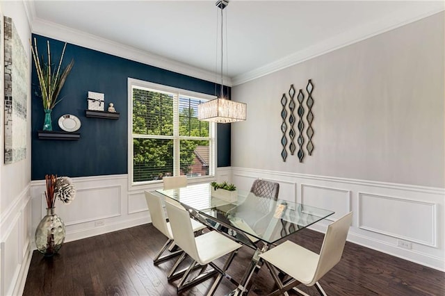 dining space featuring a decorative wall, wood-type flooring, a chandelier, a wainscoted wall, and ornamental molding
